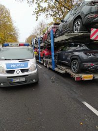miejsce zdarzenia, radiowóz policyjny stoi zaparkowany na drodze obok zestawu ciężarowego tak zwanej LORY przewożącego samochody osobowe.