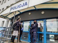 Komendant Powiatowy Policji w Bełchatowie odbiera od harcerzy betlejemski światełko pokoju.