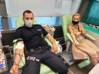 policjanci oddają krew. policjant umundurowany i policjantka po cywilnemu siedzą w krwiobusie podczas akcji honorowego krwiodawstwa
