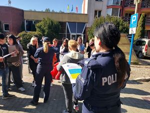 policjantki rozdają uchodźcom ulotki o zagrożeniach