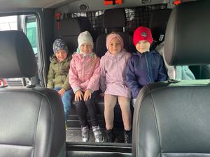 czterech przedszkolaków siedzących wewnątrz radiowozu policyjnego