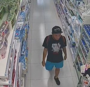 Mężczyzna poszukiwani przez bełchatowską policję. Jego wizerunek zarejestrowały kamery na miejscu zdarzenia. mężczyzna idzie pomiędzy regalami w sklepie.