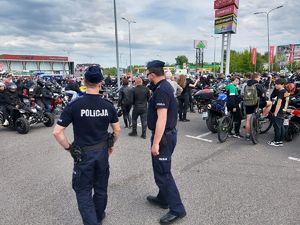 policjanci pilnują porządku, w tle zlot motocyklistów na placu przed galerią.