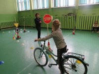 egzamin na kartę rowerową, dziewczynka w obecności policjantki jadąca na rowerze pokonuje tor przeszkód. egzamin miał miejsce w SzP nr 8 w Bełchatowie