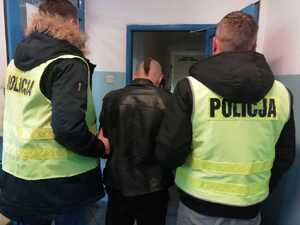 policjanci prowadzą zatrzymanego