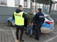 Policjanci prowadzą zatrzymanego.