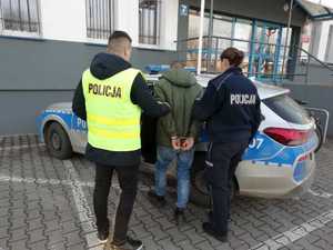 Policjanci prowadzą zatrzymanego.