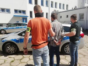 policjanci prowadzą sprawcę pobicia