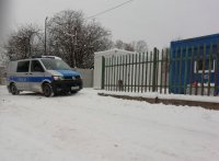 radiowóz policyjny przy miejscu gdzie pomieszkują osoby bezdomne. Zima