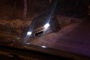 miejsce zdarzenia po zmroku, samochód stojący na ośnieżonym polu z włączonymi światłami