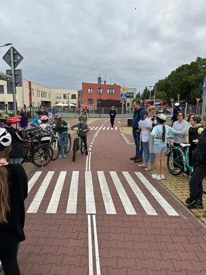 spotkanie z uczniami, policjanci egzaminują młodych rowerzystów w ramach praktycznego egzaminu na kartę rowerową.