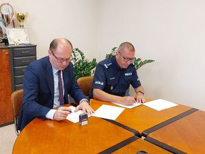 komendant policji i wójt Szczercowa podpisują dokumenty.