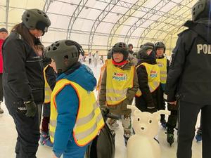dwie policjantki na łyżwach z grupa dzieci na lodowisku, działania w ramach akcji bezpieczne ferie.