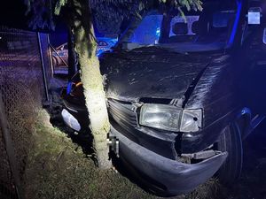 miejsce zdarzenia drogowego, volkswagen transporter uderzył w przydrożne drzewo, w tle radiowóz policyjny.