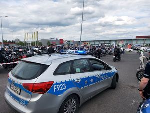 radiowóz policyjny, w tle zlot motocyklistów.