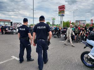 policjanci pilnują porządku, w tle zlot motocyklistów na placu przed galerią.