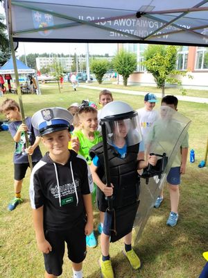 Wydarzeniu Bezpieczne Wakacje w Powiatowy Centru Sportu, na zdjęciu dzieci z elementami policyjnego wyposażenia.