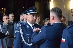 zdjęcie policjantów z uroczystości obchodów święta Policji w Bełchatowie. Policjanci odbierają awanse z rąk Komendanta Wojewódzkiego Policji w Lodzi.