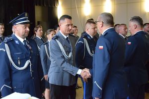zdjęcie policjantów z uroczystości obchodów święta Policji w Bełchatowie. Policjanci odbierają awanse z rąk Komendanta Wojewódzkiego Policji w Lodzi.