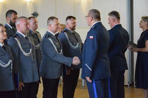 zdjęcie policjantów z uroczystości obchodów święta Policji w Bełchatowie. Policjanci odbierają awanse z rąk Komendanta Wojewódzkiego Policji w Lodzi.