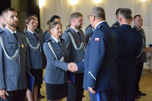 zdjęcie policjantów z uroczystości obchodów święta Policji w Bełchatowie. Policjanci odbierają awanse z rąk Komendanta Wojewódzkiego Policji w Lodzi.