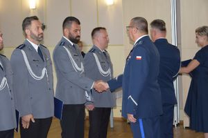 zdjęcie policjantów z uroczystości obchodów święta Policji w Bełchatowie. Policjanci odbierają awanse z rąk Komendanta Wojewódzkiego Policji w Lodzi.
