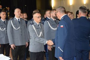 zdjęcie policjantów z uroczystości obchodów święta Policji w Bełchatowie. Policjanci odbierają awanse z rąk Komendanta Wojewódzkiego Policji w Lodzi.