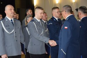 zdjęcie policjantów z uroczystości obchodów święta Policji w Bełchatowie. Policjanci odbierają awanse z rąk Komendanta Wojewódzkiego Policji w Lodzi.