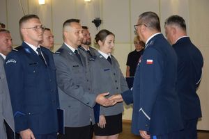 zdjęcie policjantów z uroczystości obchodów święta Policji w Bełchatowie. Policjanci odbierają awanse z rąk Komendanta Wojewódzkiego Policji w Lodzi.