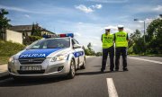 policjanci umundurowani stoją na drodze obok radiowóz dalej droga.