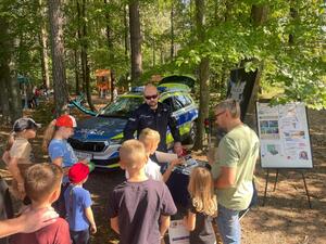 teren leśniczówki, policjant rozmawia z osobami odwiedzającymi policyjne stoisko.