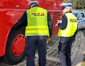 policjanci z ruchu drogowego w czasie kontroli pojazdu, sprawdzają tarcze hamulcowe.