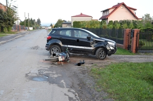 miejsce wypadku w Domiechowicach, na zdjęciu pojazd stojący na podjeździe przed bramą posesji, przed autem leży na drodze motocykl.