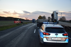 miejsce śmiertelnego wypadku drogowego, radiowóz policyjny na drodze, dalej pojazd uczestniczący w zdarzeniu.