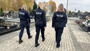 trzy policjantki patrolują teren cmentarza.