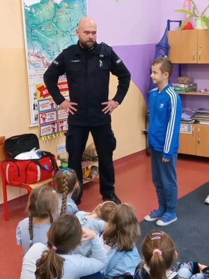 policjant na spotkaniu w szkole z uczniami.