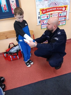 policjant na spotkaniu w szkole z uczniami.