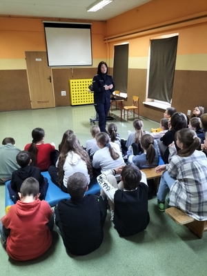 policjant na spotkaniu w szkole z uczniami.