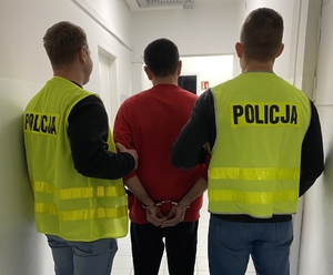 Na zdjęciu dwaj funkcjonariusze Policji z osobą zatrzymaną.