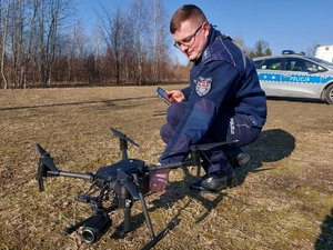 policjant, który obsługuje drona.