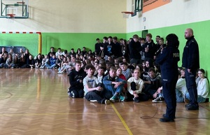 policjanci na spotkaniu z młodzieżą w sali szkoły.