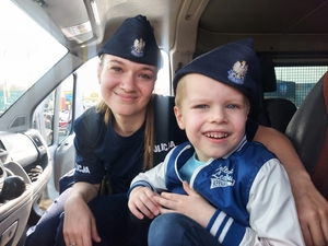 policjantka i dziecko siedzą w samochodzie.