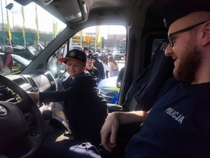 policjant pokazuje dziecku wnętrze radiowozu.