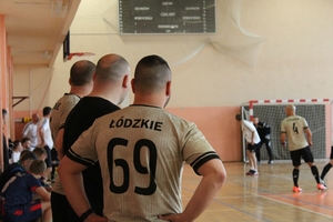 mężczyźni zawodnicy w czasie gry w piłkę nożną na hali sportowej.