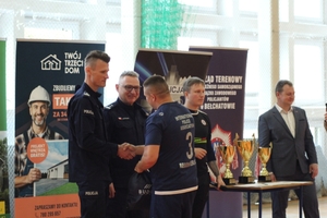 komendanci gratulują zawodnikom po zakończeniu turnieju  piłki nożnej na hali sportowej.