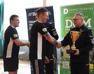 komendanci gratulują zawodnikom po zakończeniu turnieju  piłki nożnej na hali sportowej.