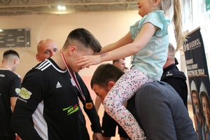 komendanci gratulują zawodnikom po zakończeniu turnieju  piłki nożnej na hali sportowej.