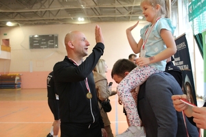 komendanci gratulują zawodnikom po zakończeniu turnieju  piłki nożnej na hali sportowej.