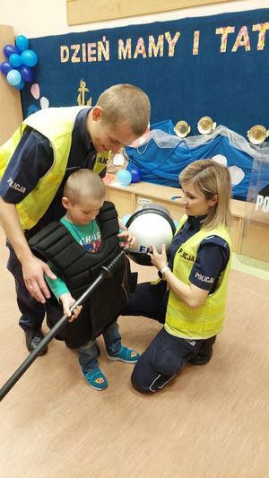 spotkanie policjantów z dziećmi w szkole. policjanci pokazują przedszkolakom policyjny kask.