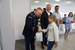 komendant policji gratuluje dziecku zwycięstwa.